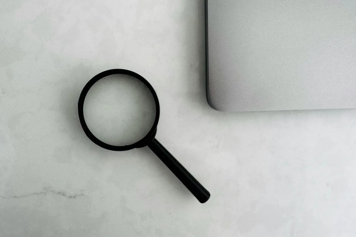 Magnifying glass beside a laptop for IB results review