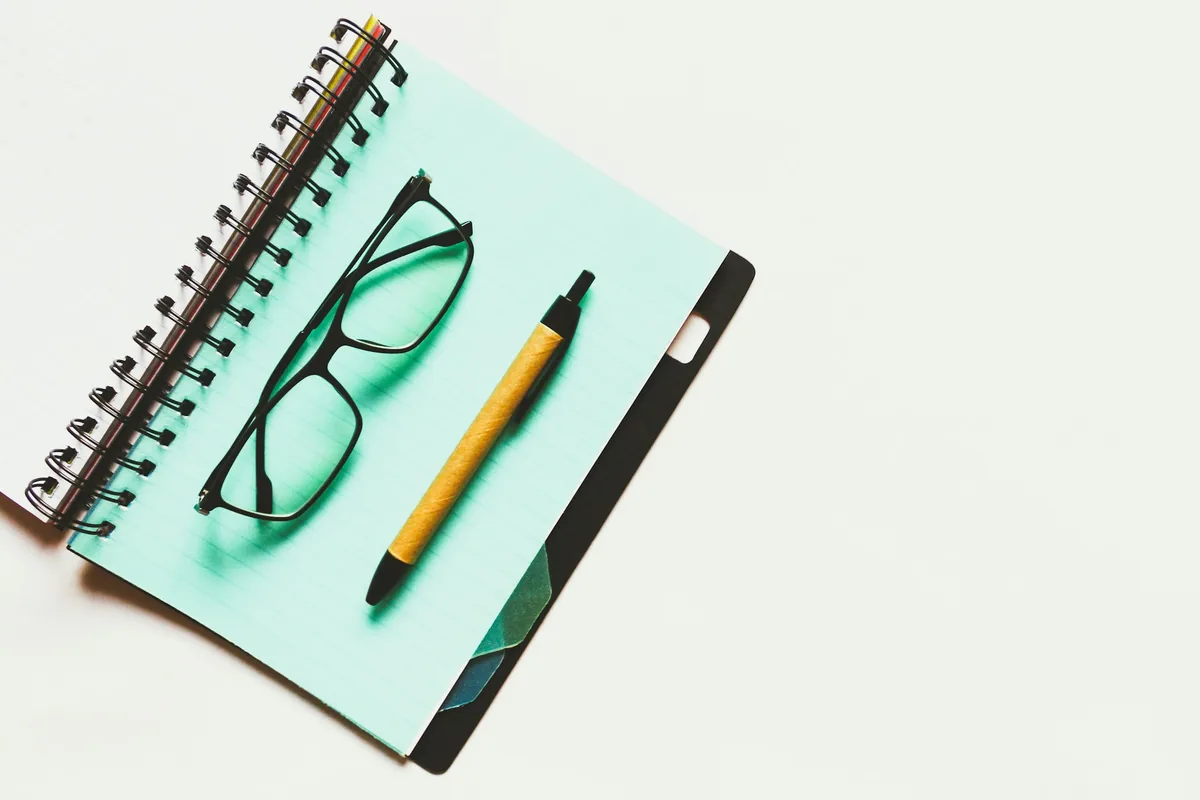 Notebook, pen and glasses for IB retake questions